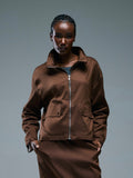 Person wearing a brown jacket  from RÓLO and pants against a gray background