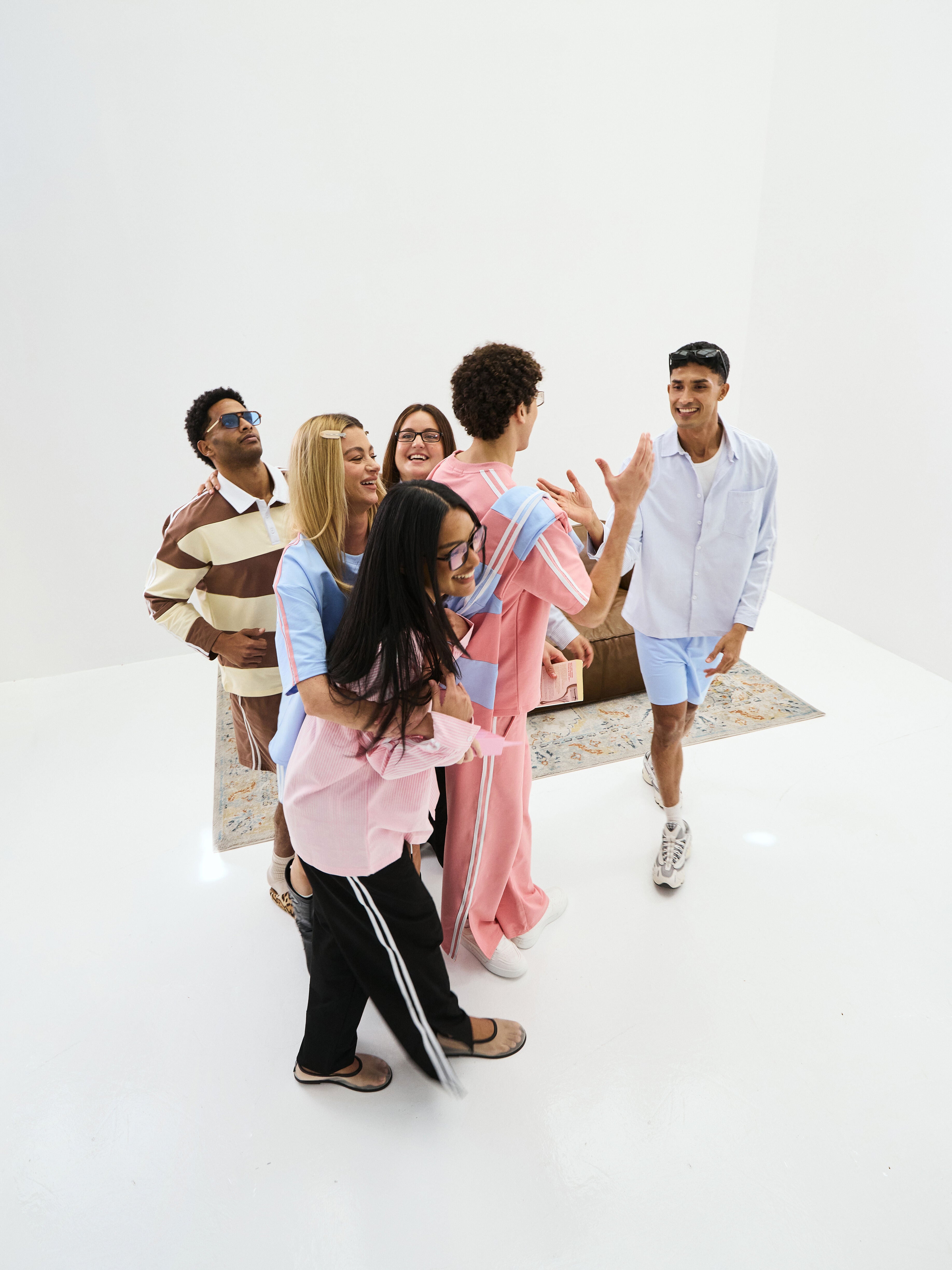 Group of people interacting in a casual setting on a white background and wearing rolo brand